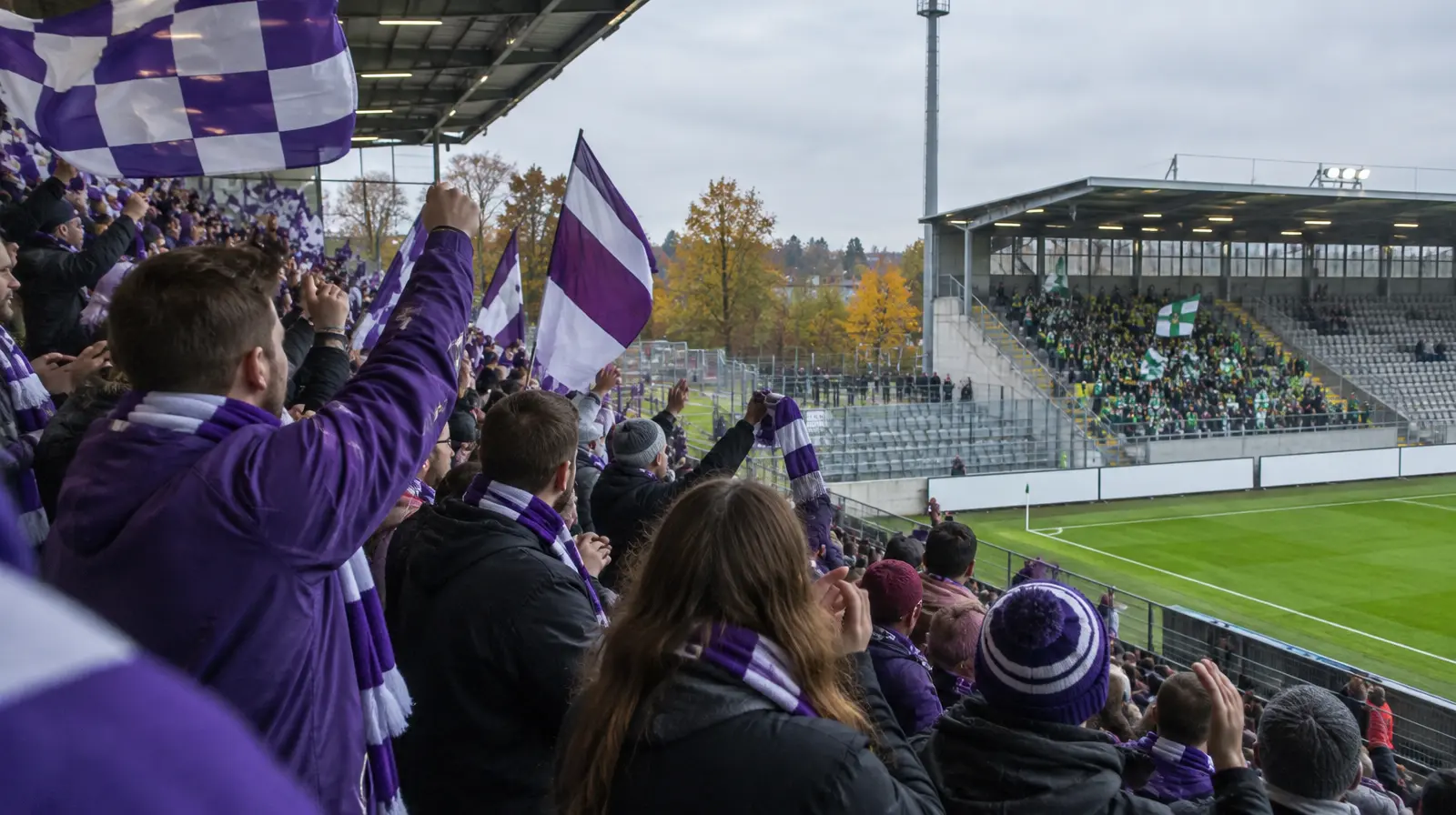 Hemmasupportrar i lila och vitt jublar på läktaren