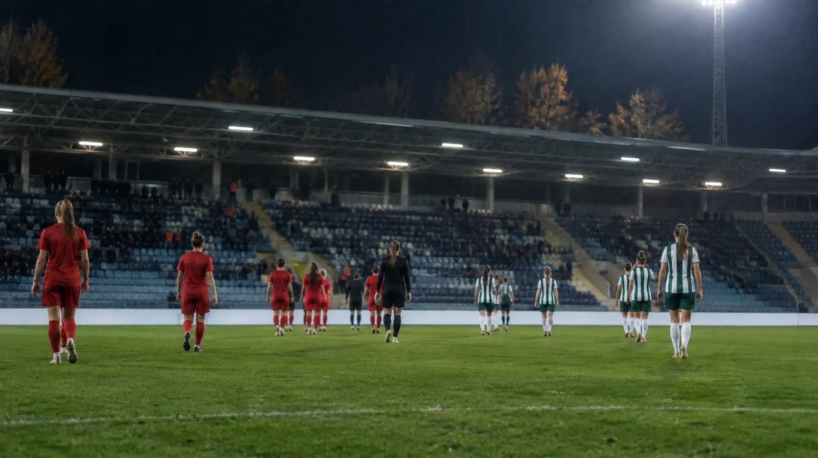 Spelare går av planen efter slutsignalen i kvällsljus på en slovakisk arena